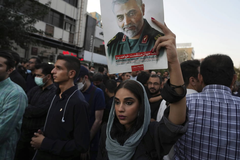 Une femme soulevant le portait de Soleimani