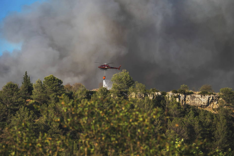 Un h&eacute;licopt&egrave;re d&eacute;verse de l'eau sur les incendies