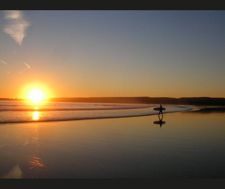 Un surfeur au coucher du soleil