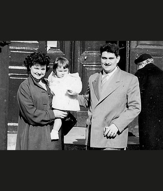 Un enfant le jour de son bapt&ecirc;me avec ses parents