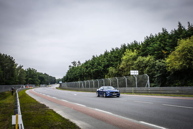Une Mustang vive à l'approche des virages Porsche